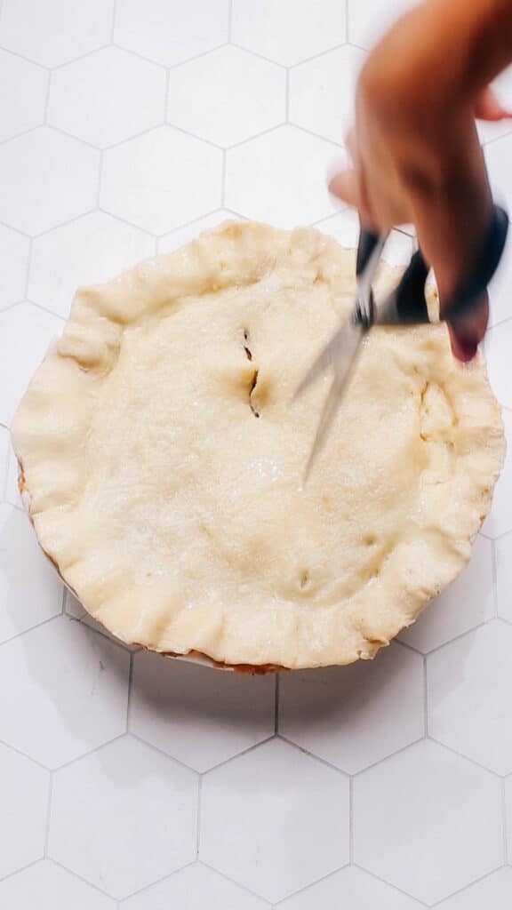 Cutting steam vents in beef pot pie before baking.