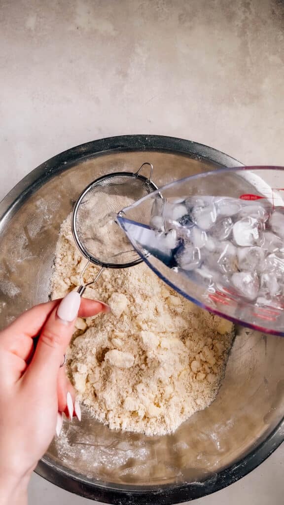 Pouring ice water through a sieve.