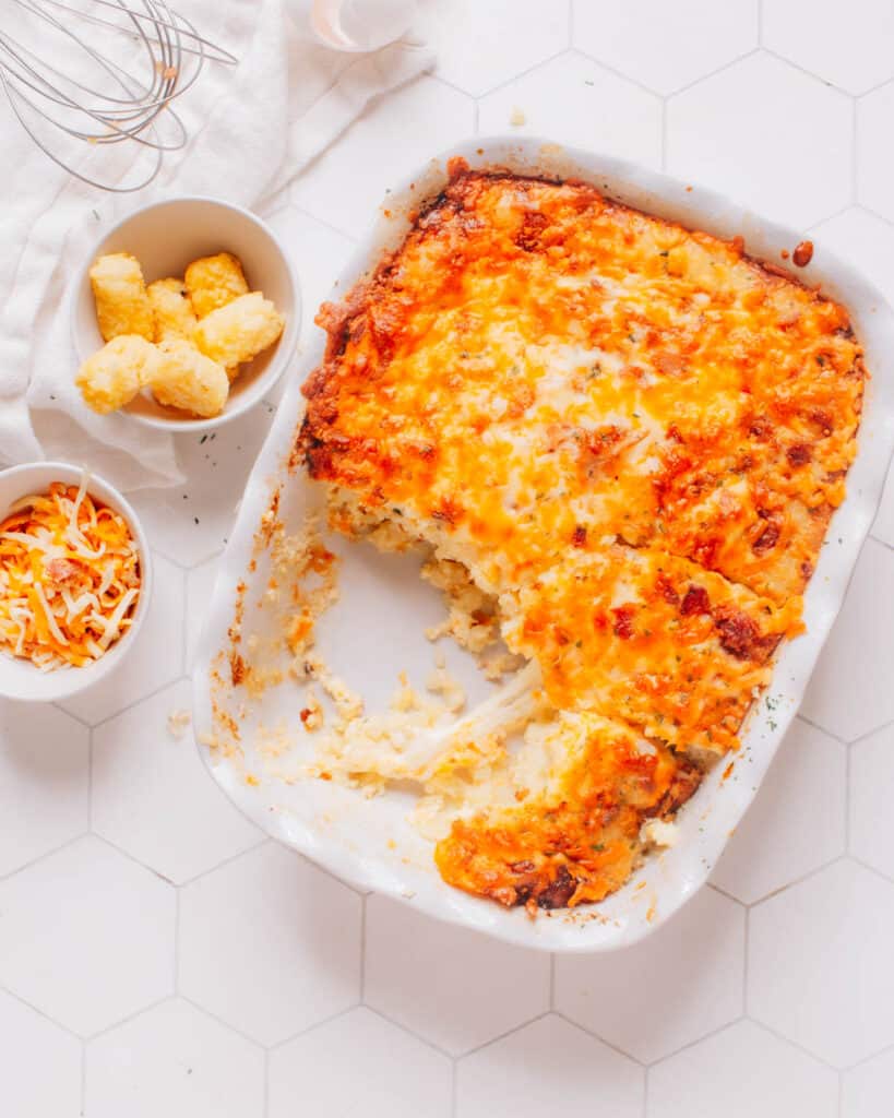 Tater tot breakfast casserole with a piece removed.