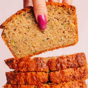 A pile of sliced zucchini bread with the top slice lifted up.