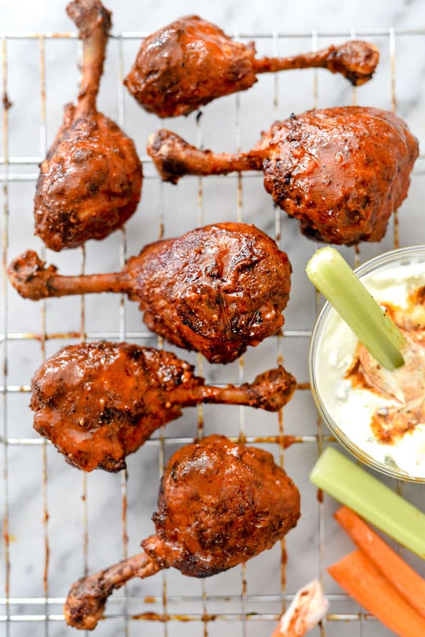Buffalo Chicken Drumsticks on a wire rack with a dip
