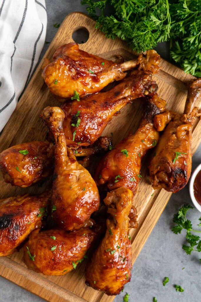 Slow Cooker BBQ Chicken Drumsticks on a wooden cutting board
