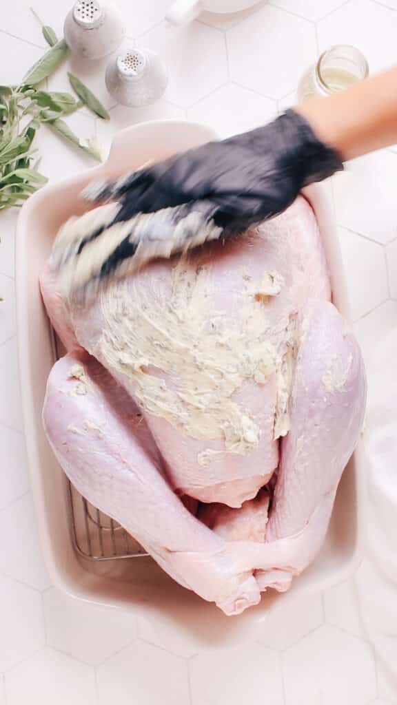 Rubbing butter on a turkey before roasting.