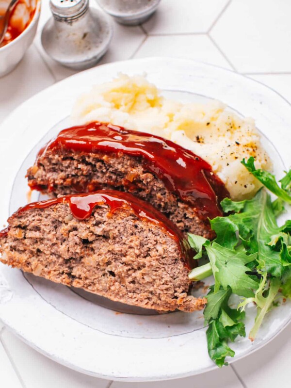 Meatloaf with Glaze on a plate with mashed potatoes.
