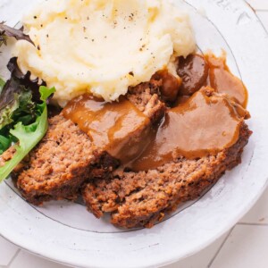 Lipton Meatloaf Recipe and gravy on a plate with side dishes.