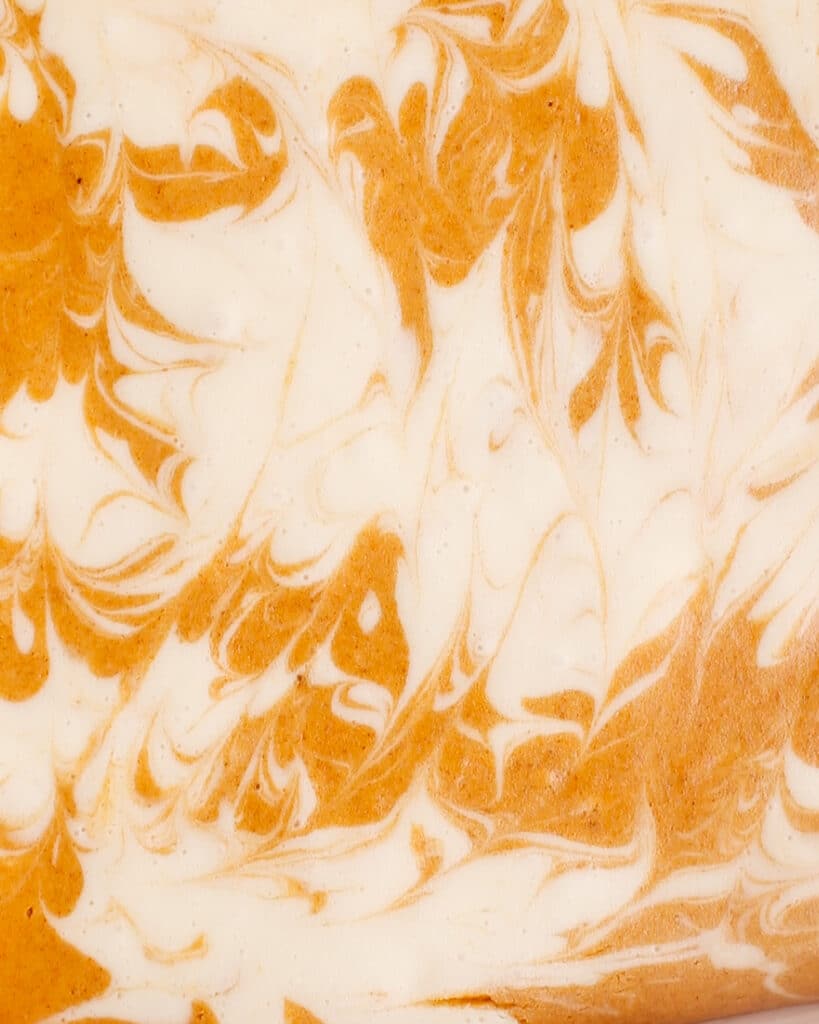 Up-close shot of the pumpkin cheesecake swirled batter.