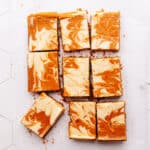 Pumpkin cheesecake bars on parchment paper.