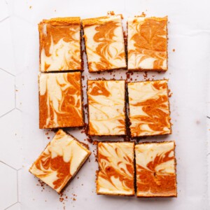 Pumpkin cheesecake bars on parchment paper.