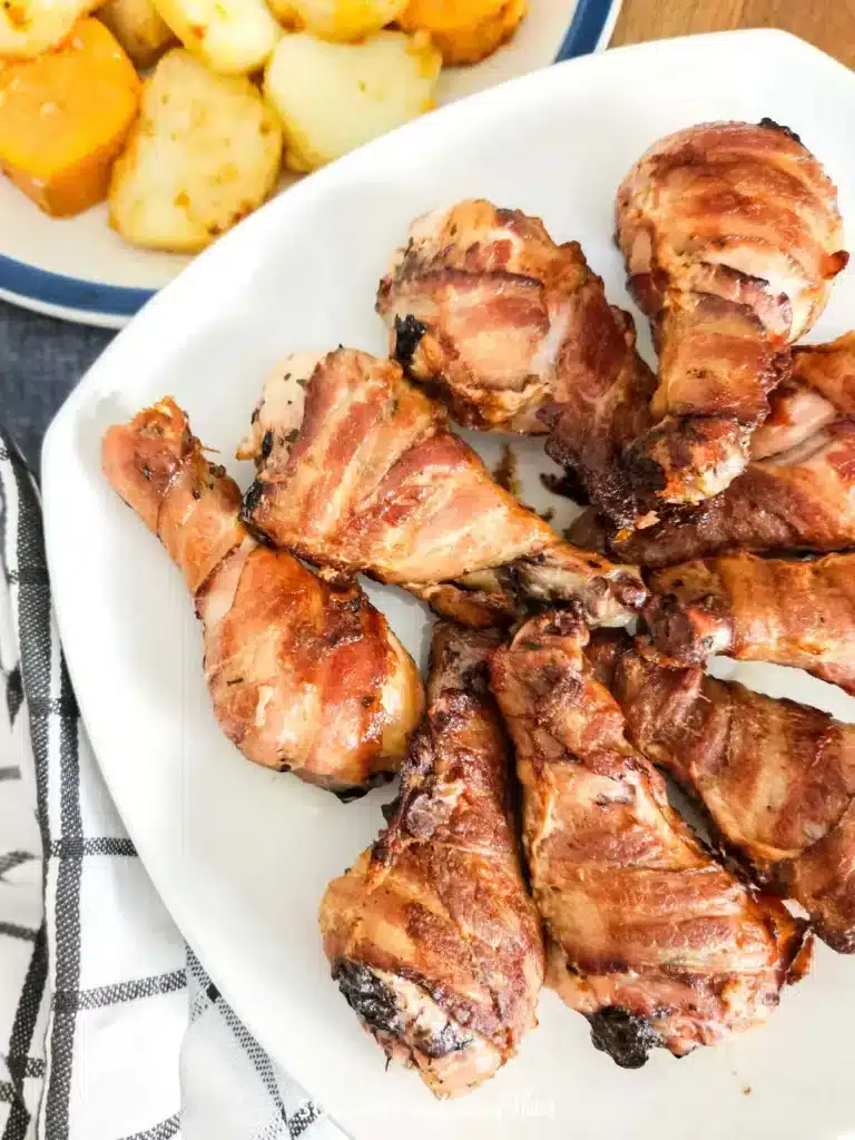 Oven-Baked Bacon Wrapped Drumsticks served on a plate
