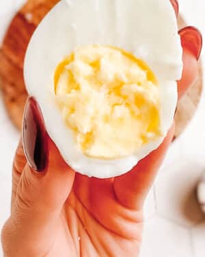 How to boil eggs in the microwave: showing the last step, peeling the microwave-boiled egg.