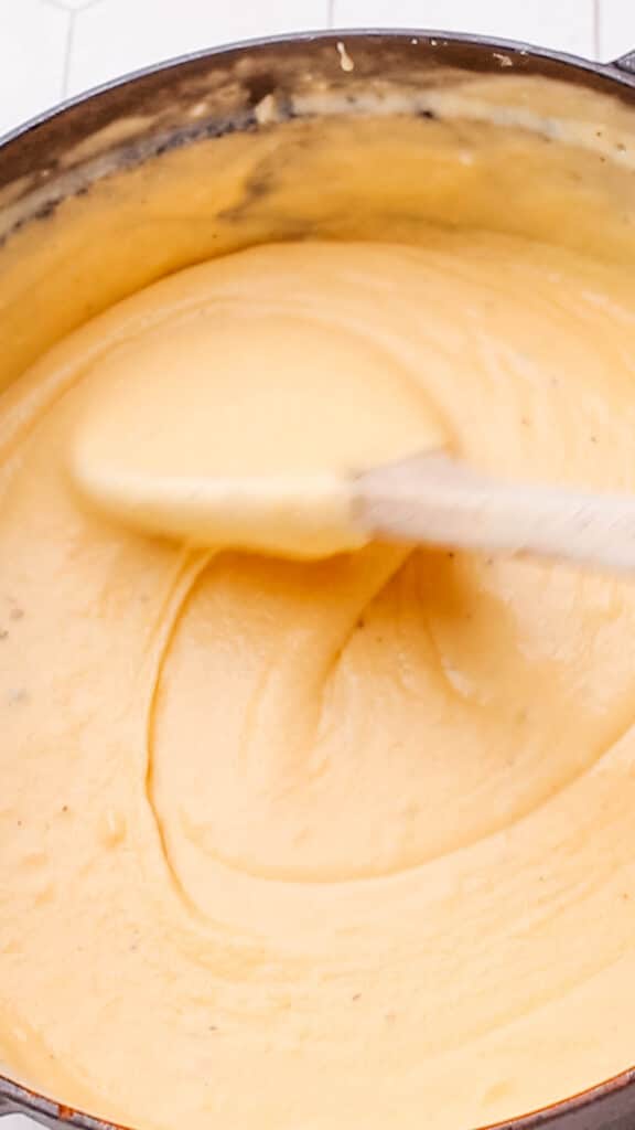 Stirring cheddar cheese sauce for maroni and cheese.