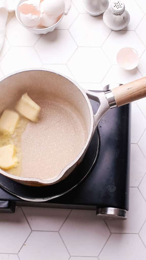 Adding butter to saucepan for gravy.