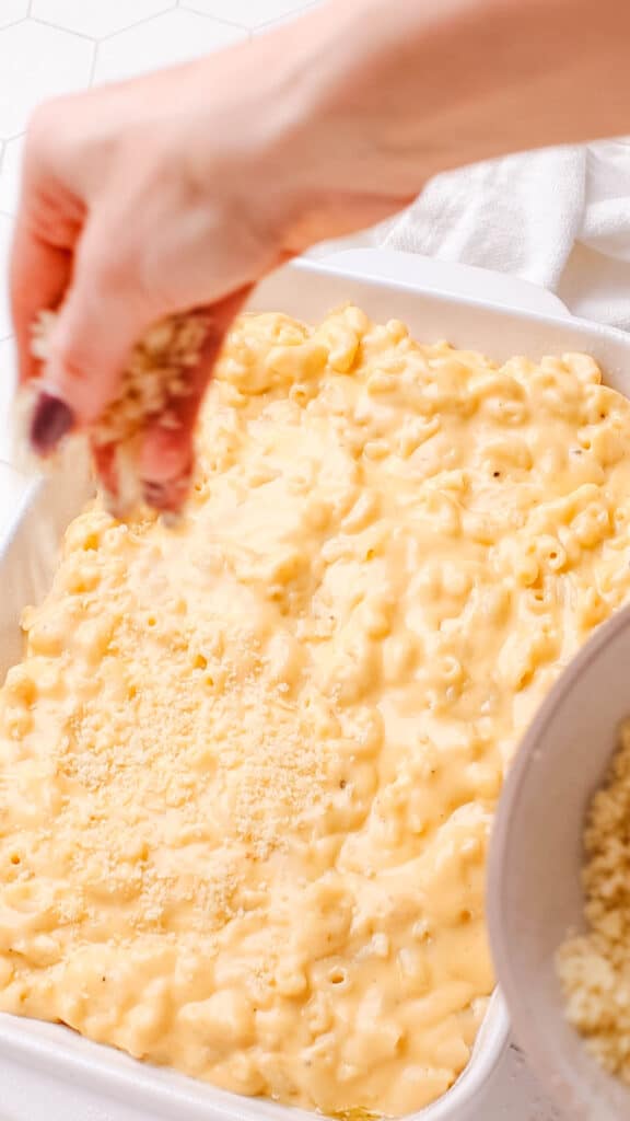 Adding bread crumbs on  baked macaroni and cheese.