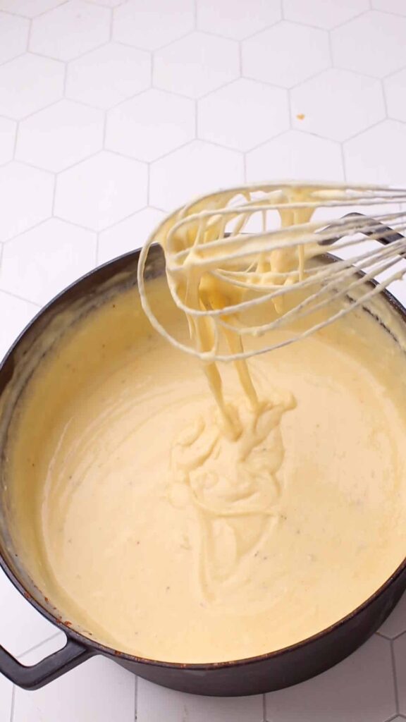 Whisking cheese sauce for mac and cheese.