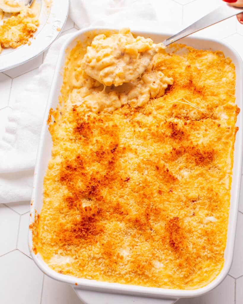 Old Fashioned Baked Macaroni and Cheese with a spoon scooping some out.