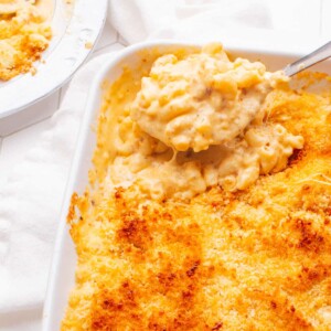 Old Fashioned Baked Macaroni and Cheese with a spoon scooping some out.