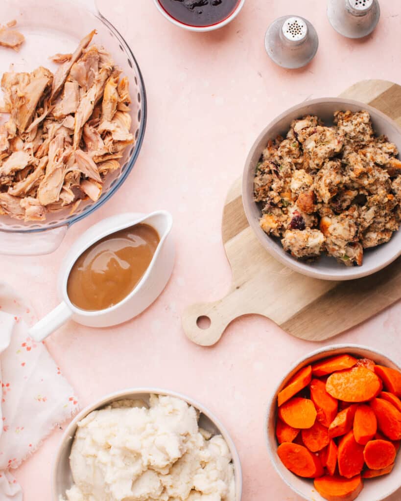 Turkey giblet gravy without drippings on a Thanskgiving table with mashed potatoes, stuffing, turkey and carrots.