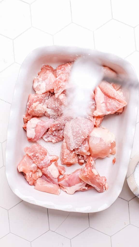 seasoning chicken with salt.