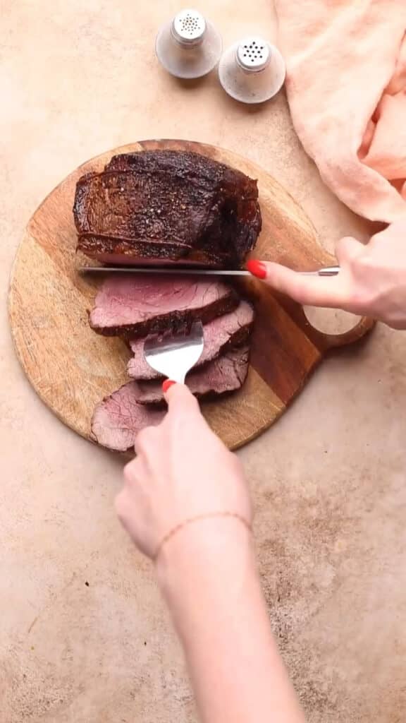 Slicing beef with knife and fork