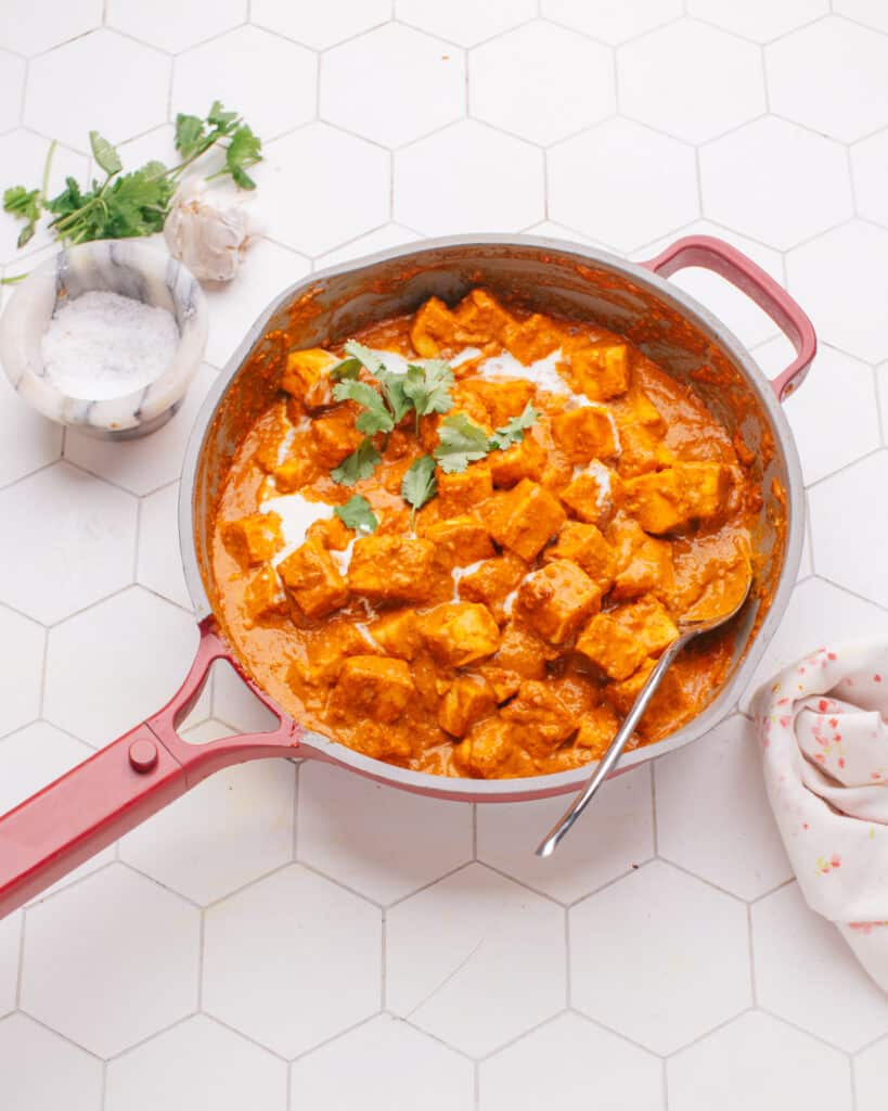 Butter Paneer in a pan with a spoon. 