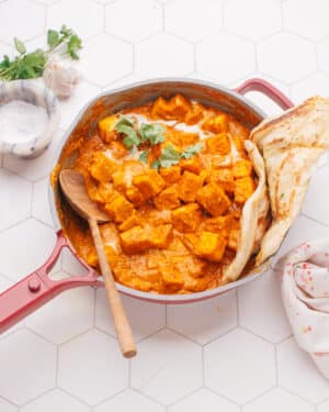 Butter paneer in a pan with naan.