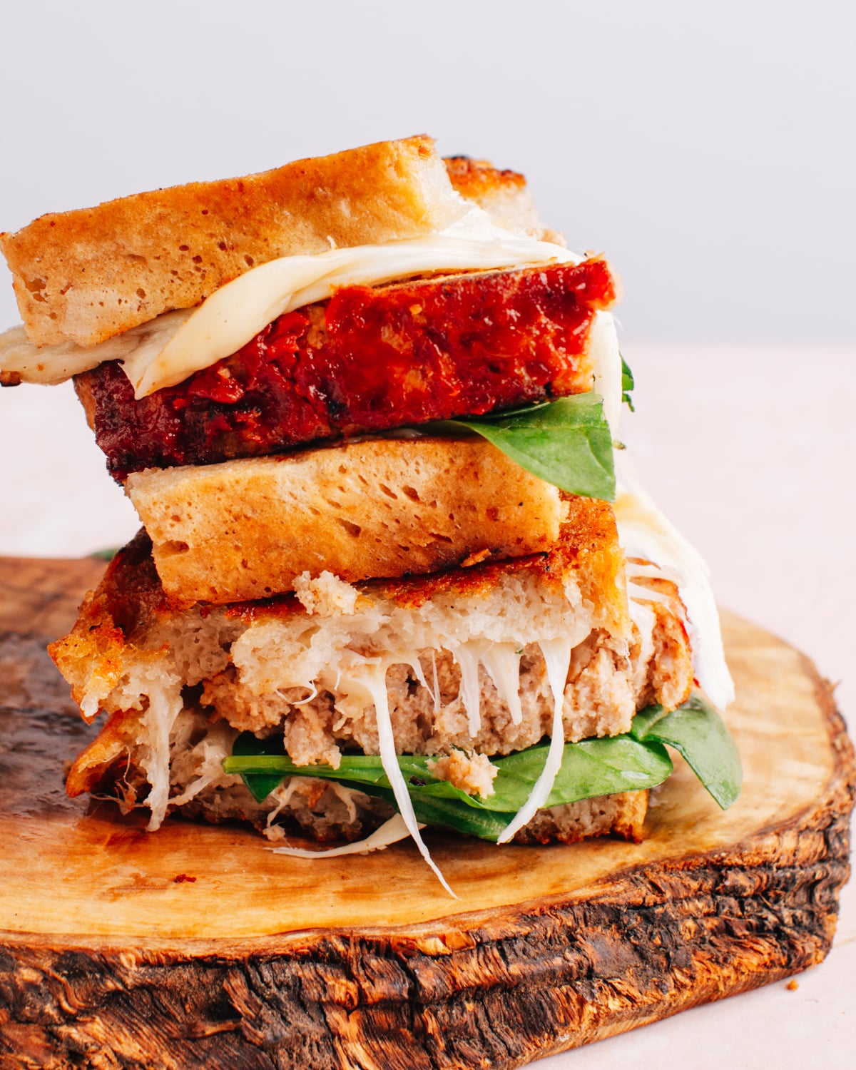 Meatloaf sandwich stacked on a cutting board.