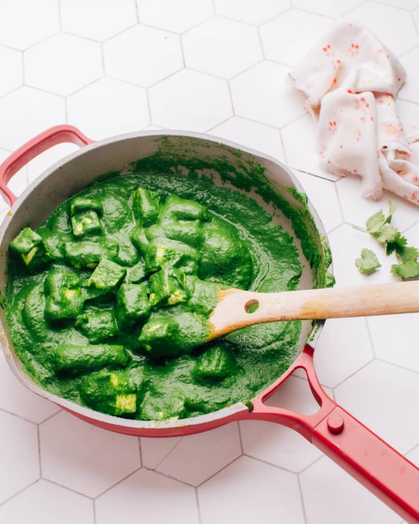 Palak Paneer recipe in a pan with a spoon.