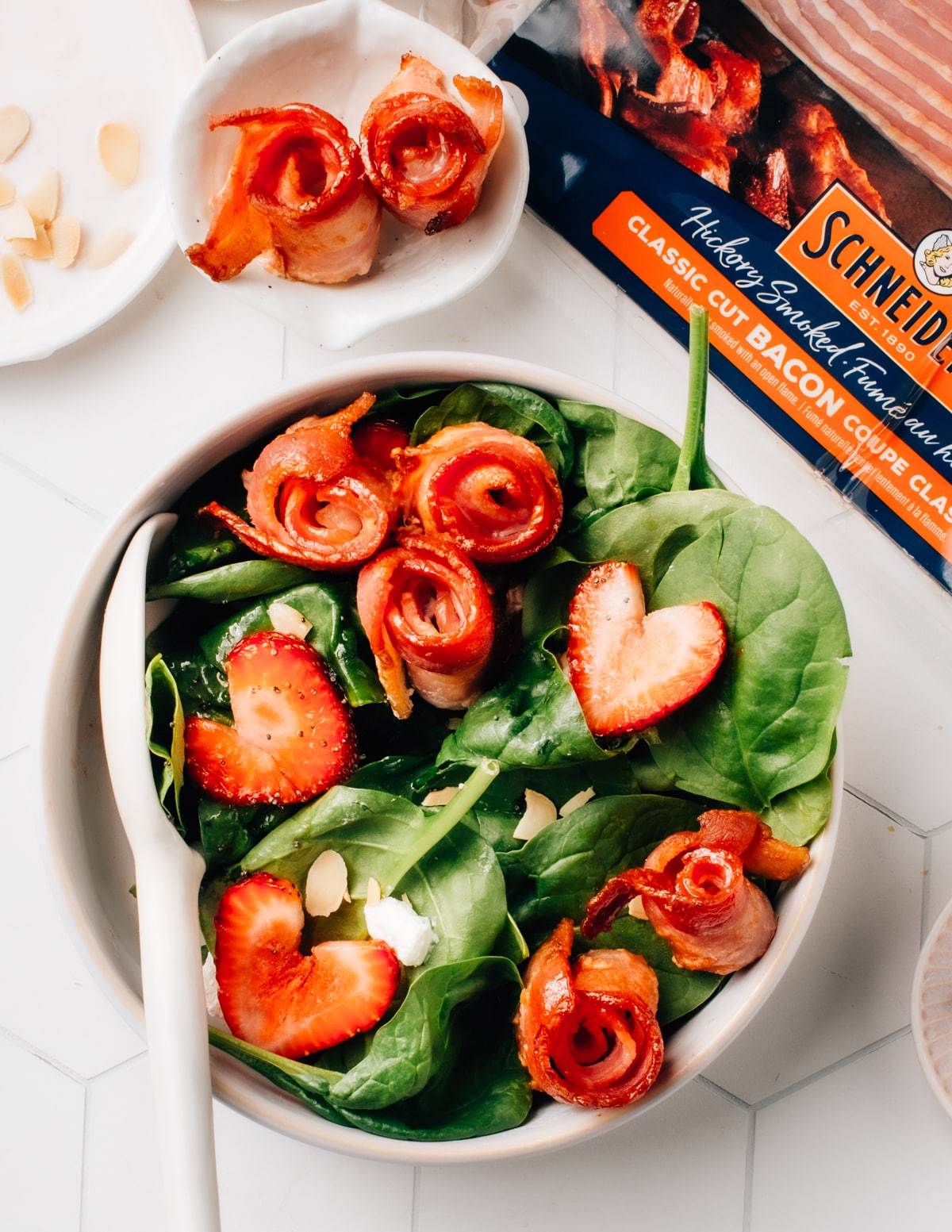 Crispy air fryer bacon on top of a spinach salad with strawberries. 
