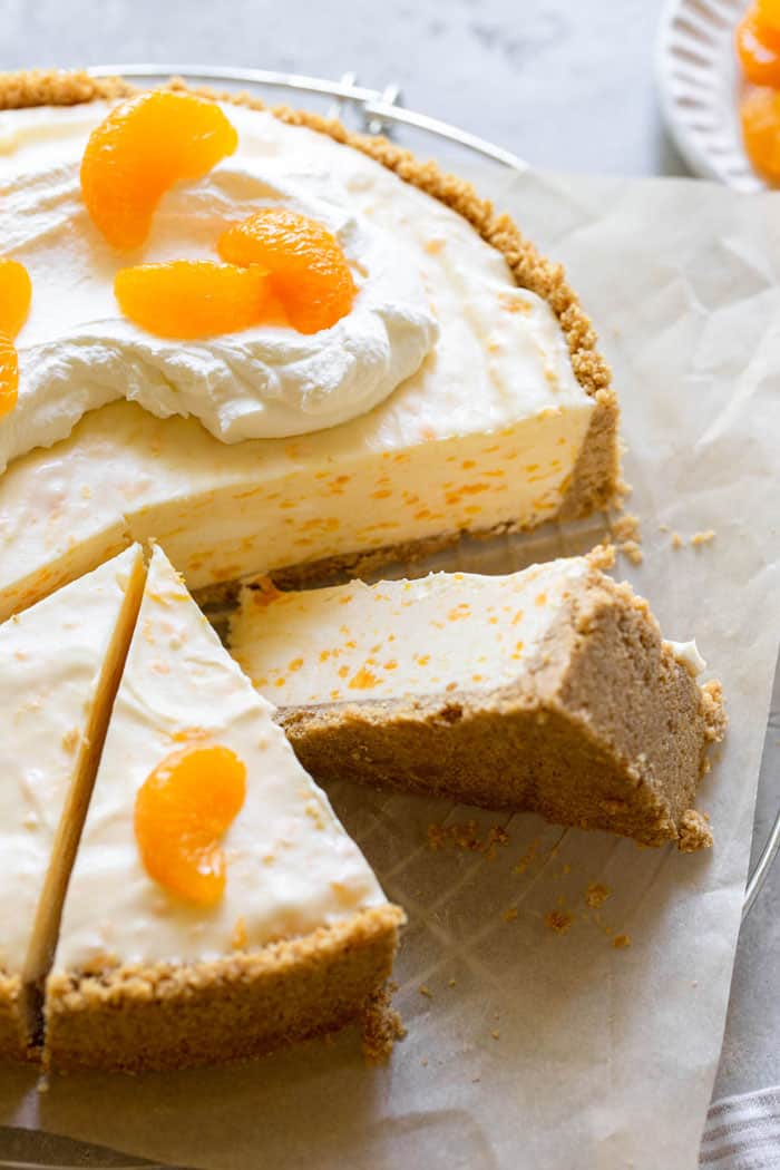 Orange dessert recipe for cheesecake with whipped cream and orange slices.