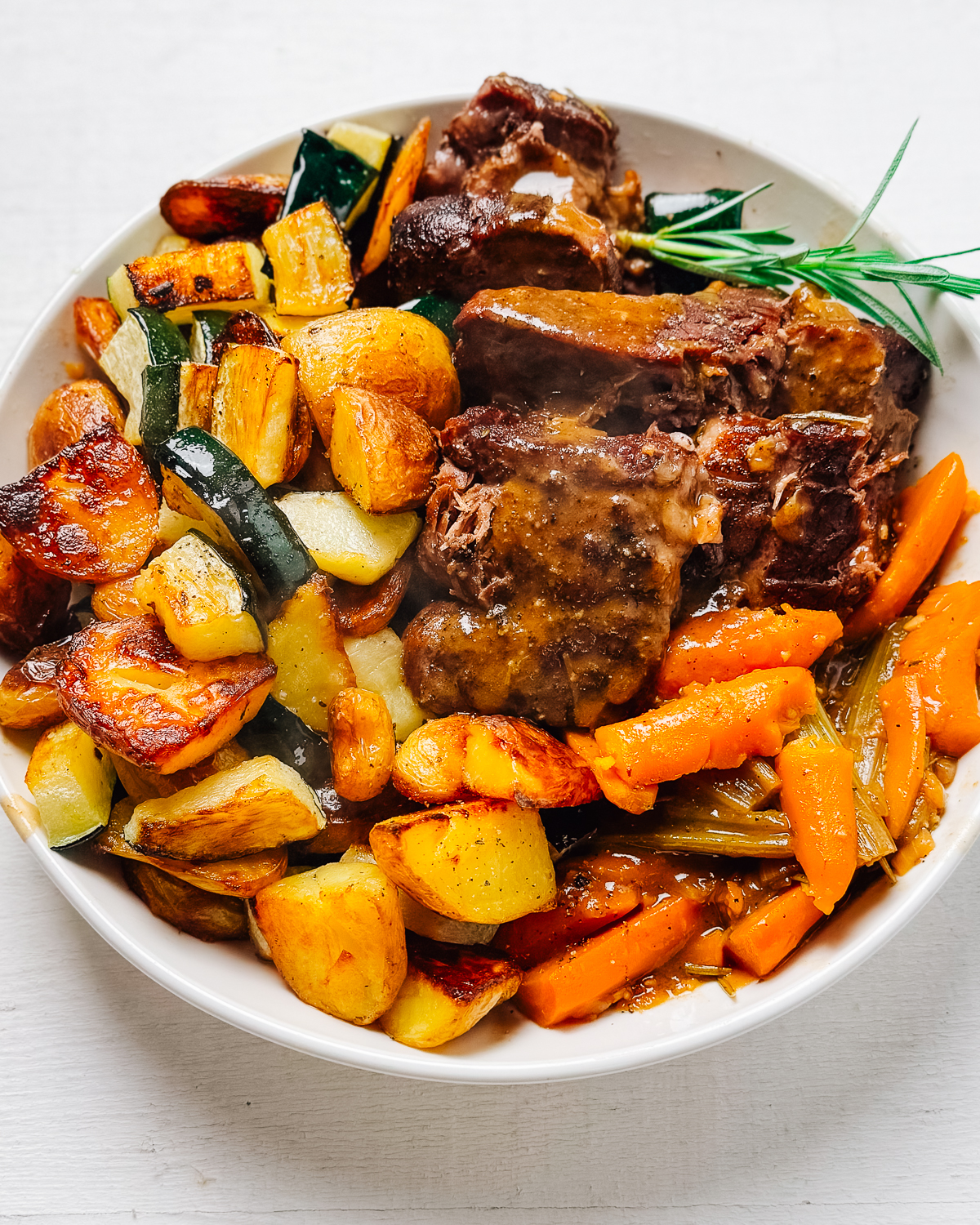 Beef chuck roast with potatoes and vegetables on a platter.