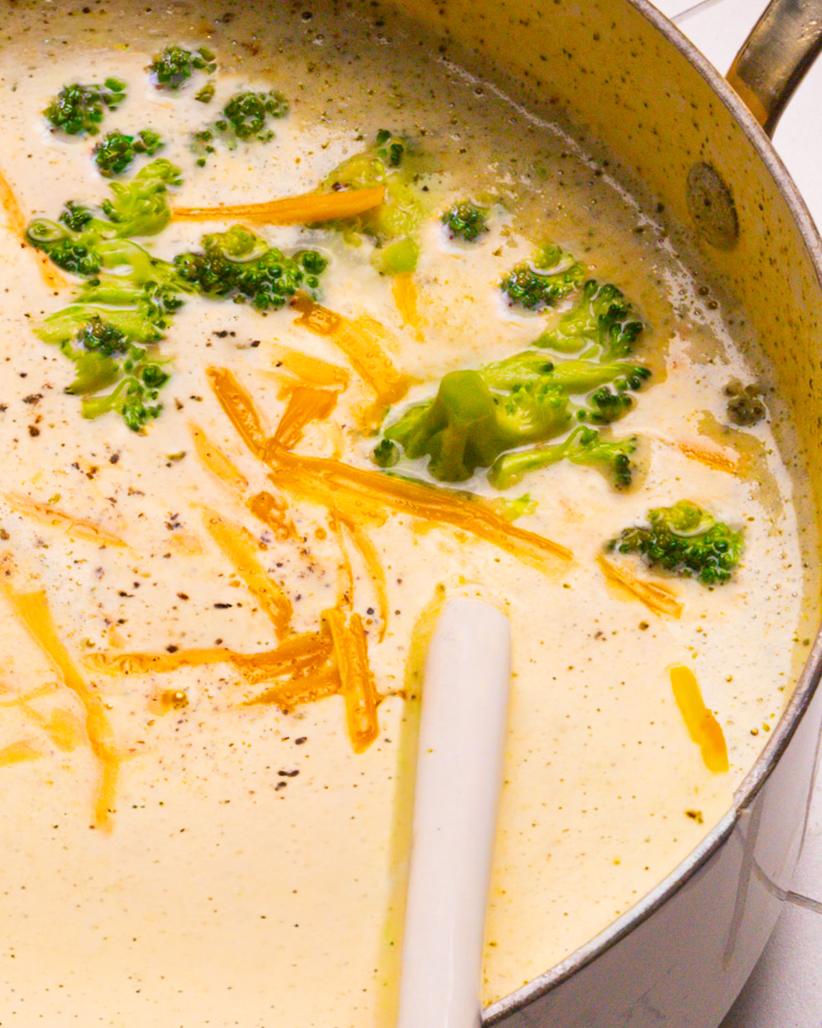 Broccoli Cheddar Soup recipe in a pot with a spoon.