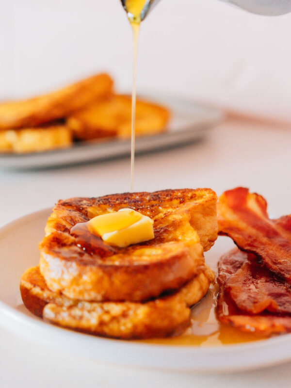 Best french toast on a plate with bacon.