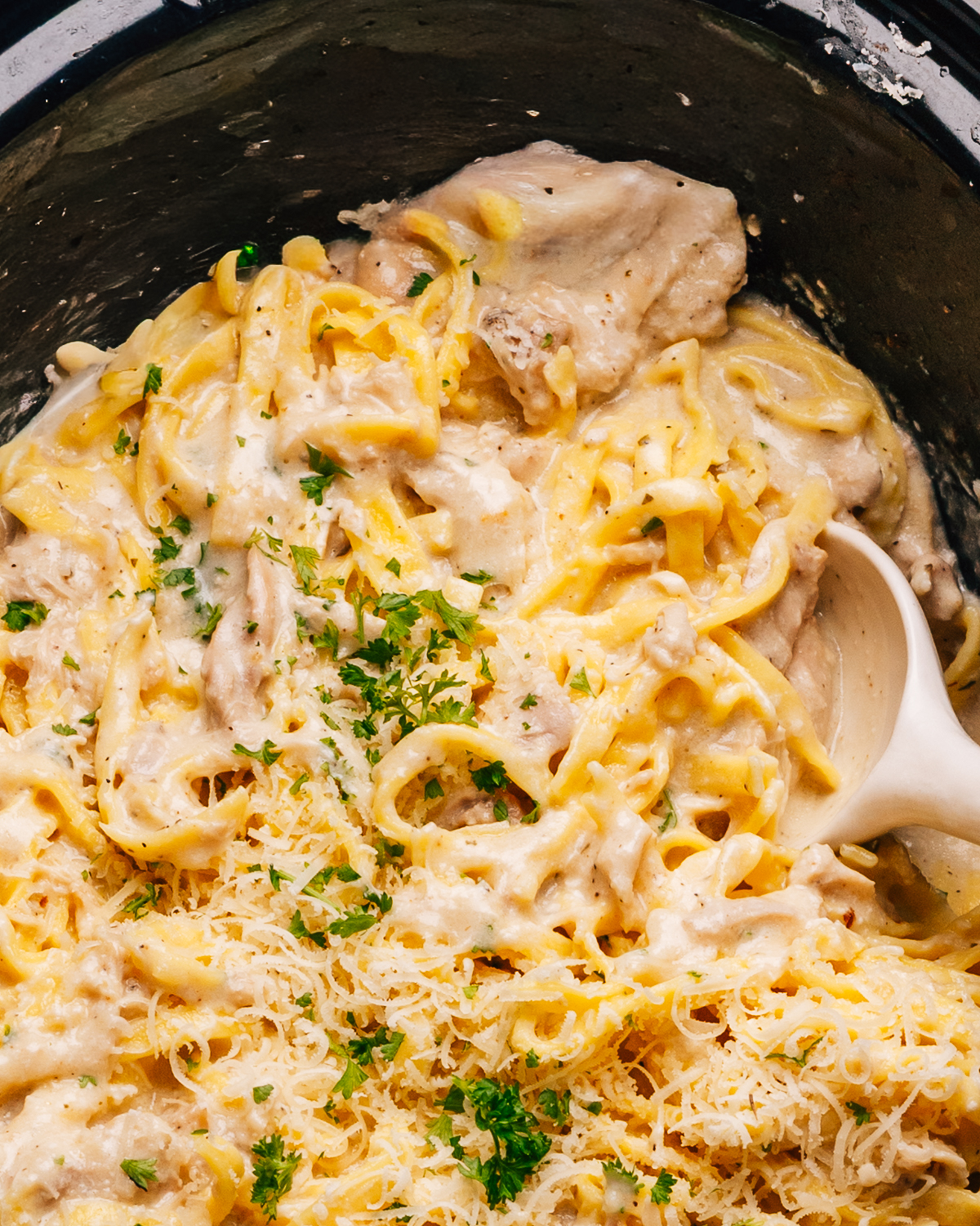 Crockpot Chicken Alfredo recipe close up shot with a spoon.