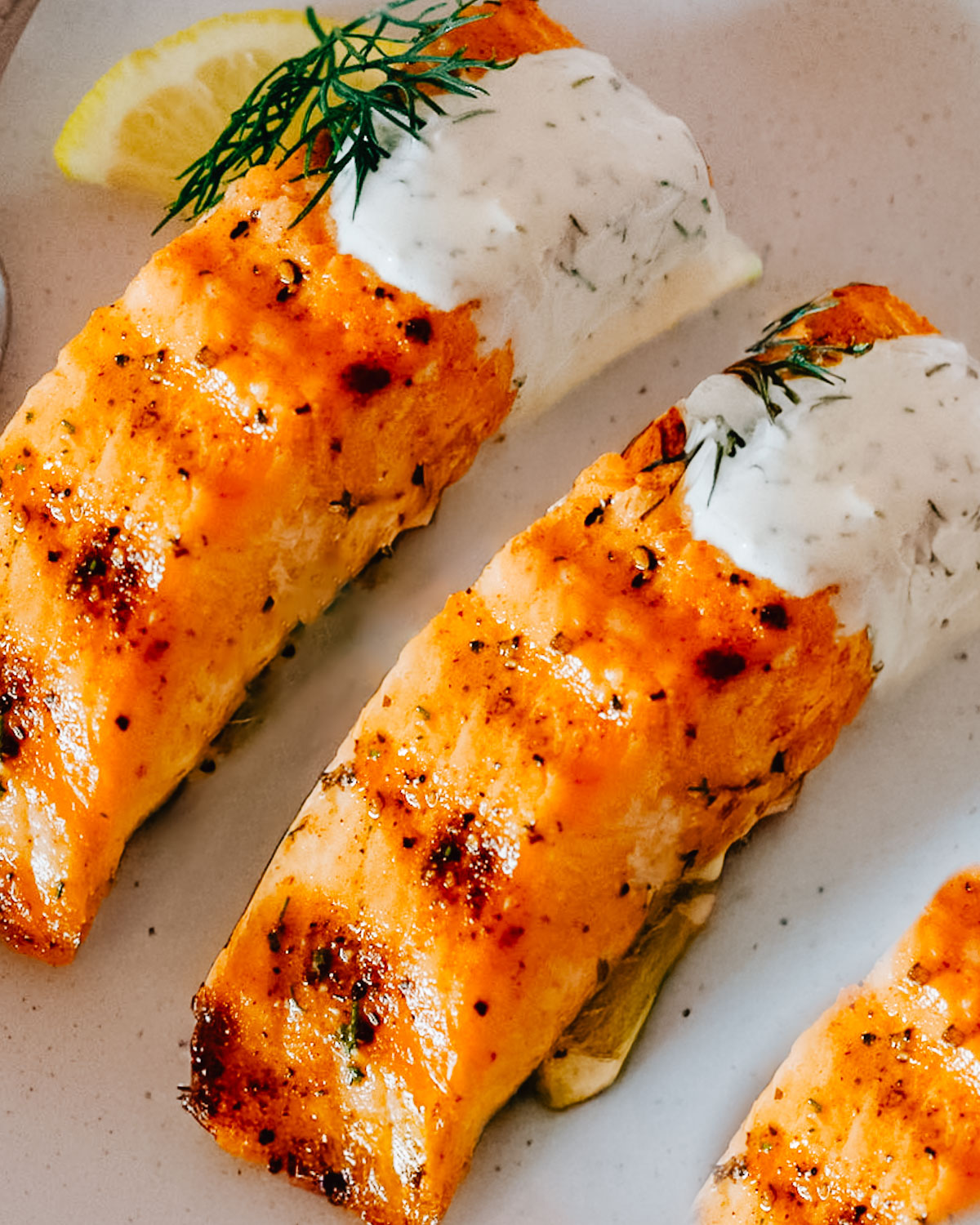 Dill Sauce for Salmon spooned over portions of grilled salmon.