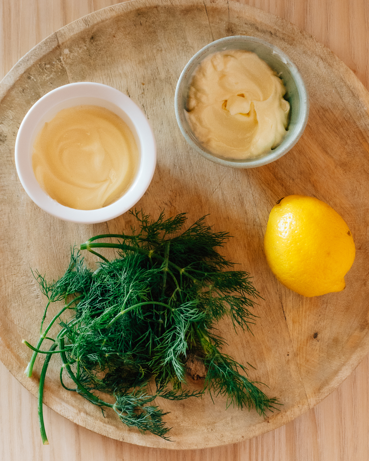 Ingredients to make Dill Sauce for Salmon, on a cutting board. 
