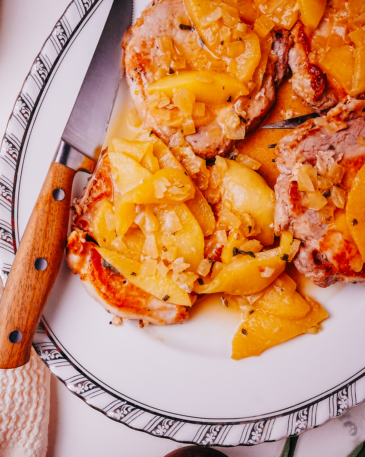 Pork Chops with Apples on a plate with a knife.