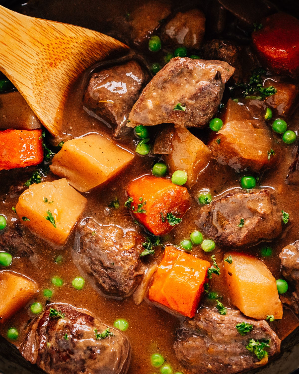 Pressure Cooker Beef Stew in Instant Pot with a wooden spoon.