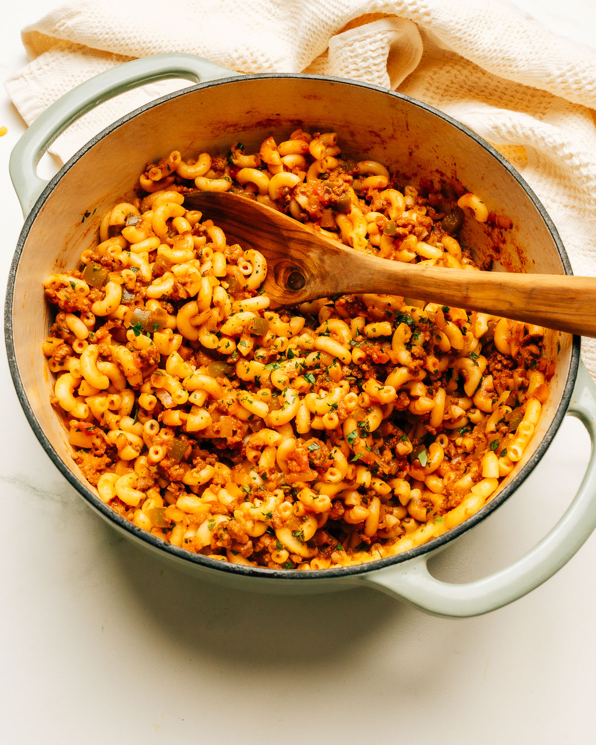 American Chop Suey Recipe in a pot with a wooden spoon.