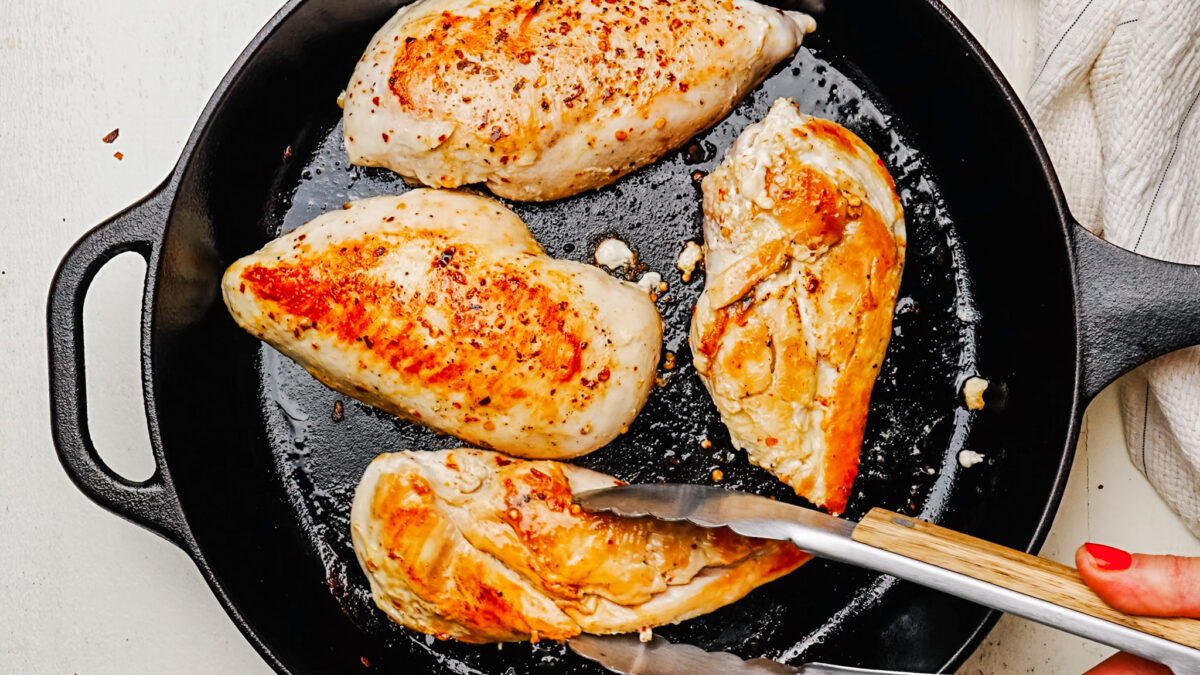Searing chicken breast in a large skillet until golden brown.