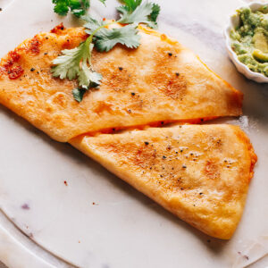 Golden and crispy Chicken quesadilla topped with cilantro.