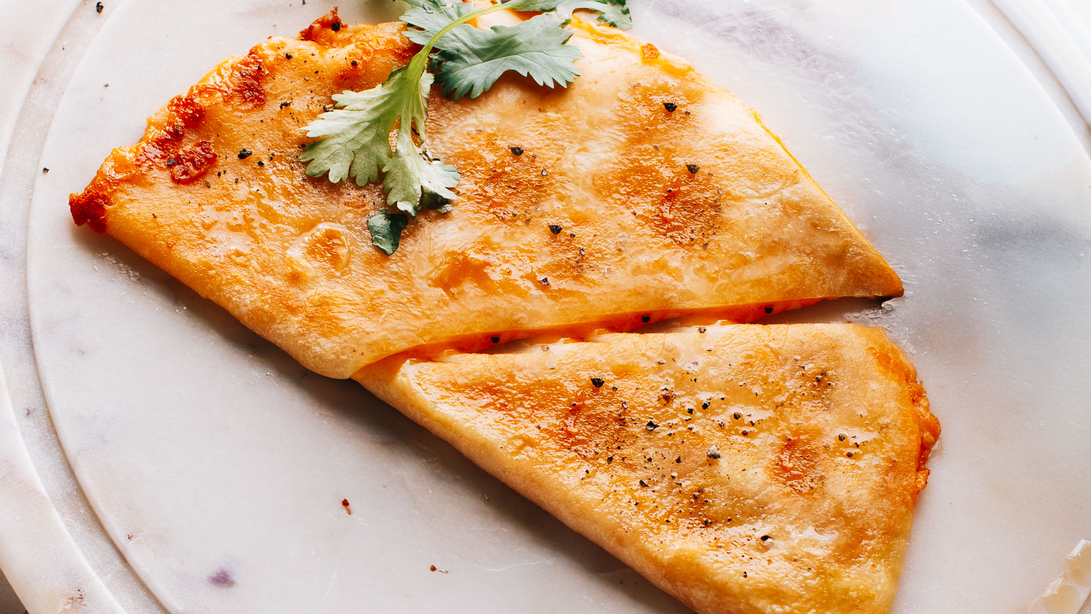A golden chicken quesadilla cut into wedges.