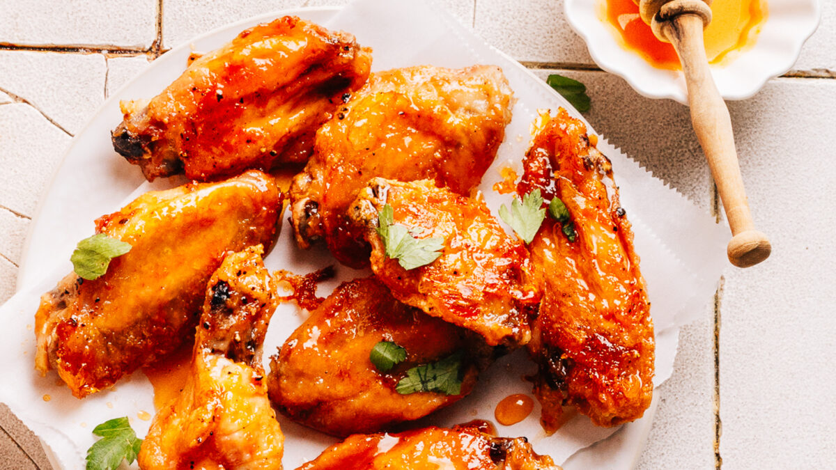 A plate of wings with hot honey sauce.