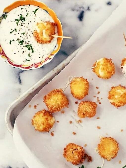 This easy, homemade, breaded Mini Mozzarella Sticks Recipe with Jalapeno Ranch Dip is crazy delicious! Serve it on a toothpick as a party appetizer and your guests are sure to fall in love with these cheesy treats!
