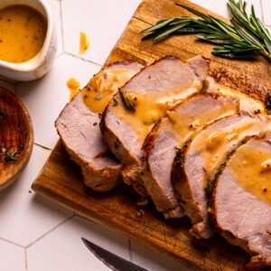 Pork gravy drizzled over roast pork loin.