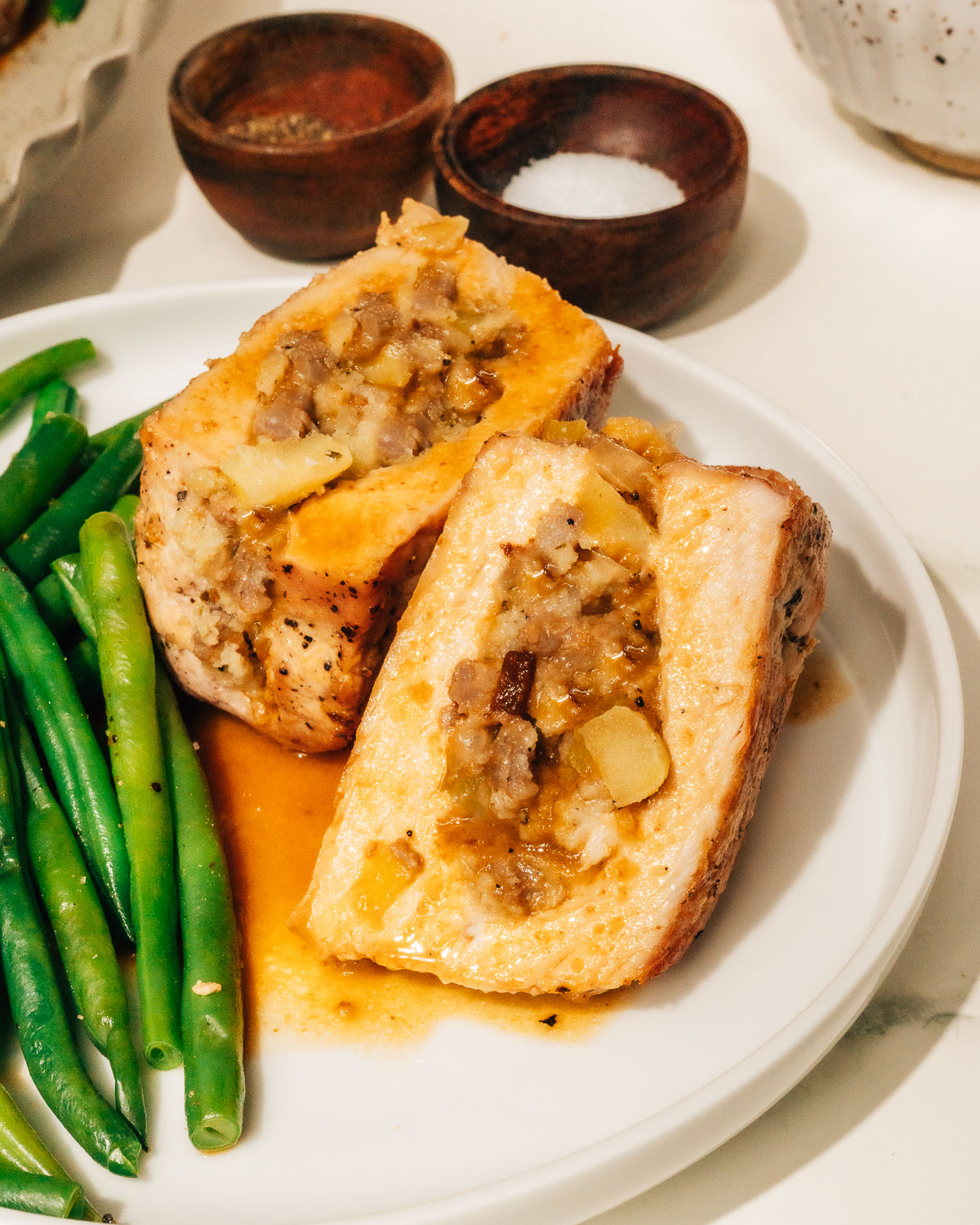 Finished stuffed pork chops recipe cut open to show the stuffing inside.