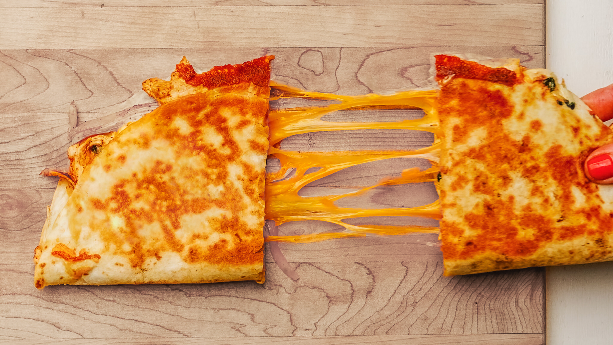 Chicken Quesadilla cheese pull on a cutting board.