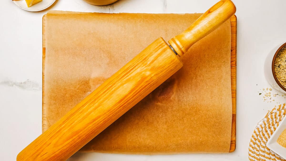 pound the chicken breast in between two parchment paper pieces with equipment like a rolling pin for chicken schnitzel.