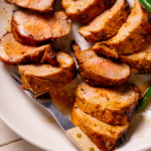 Slice marinated Pork Tenderloin recipe on a plate.