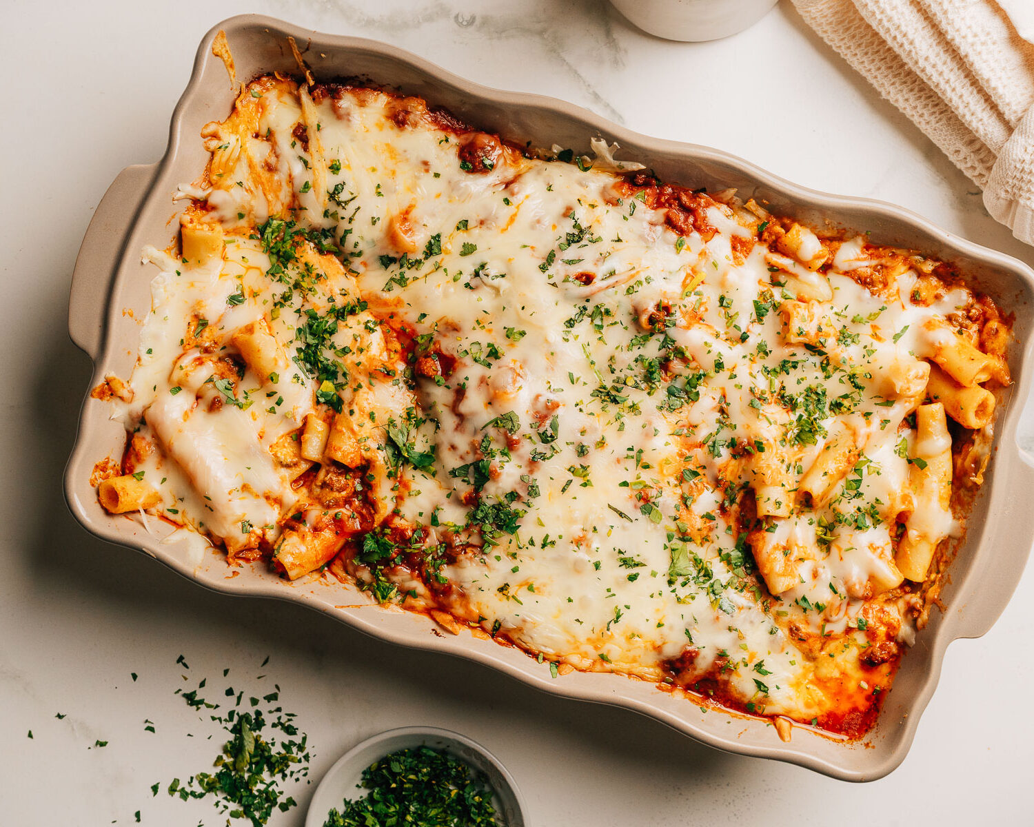 Baked ziti with ricotta topped with minced parsley.