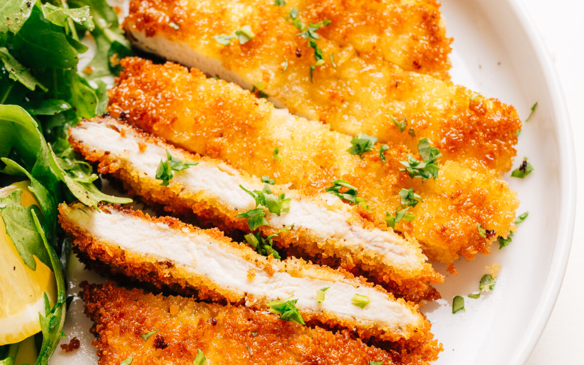 Plated chicken schnitzel recipe on a plate with parsley.